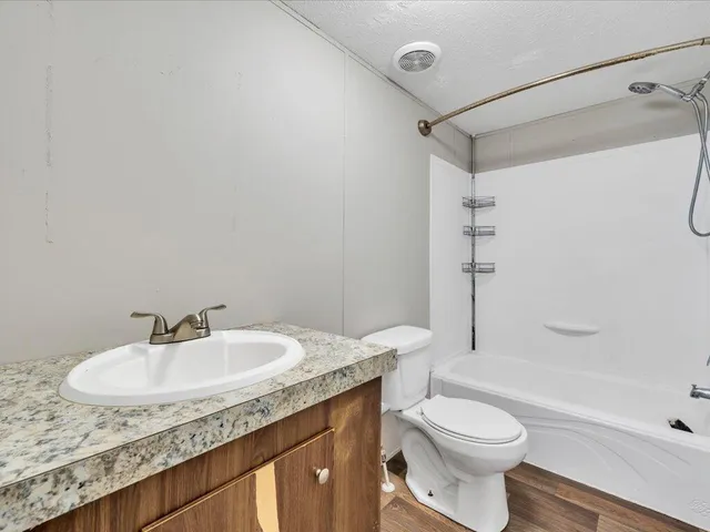 a bathroom with a sink toilet vanity and shower