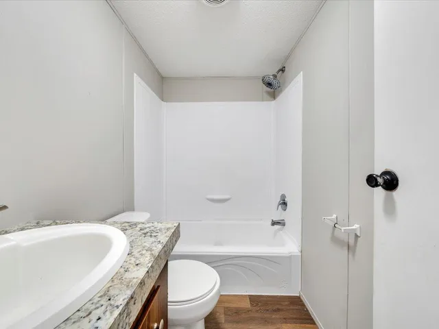 a bathroom with a granite countertop bathtub toilet and a sink
