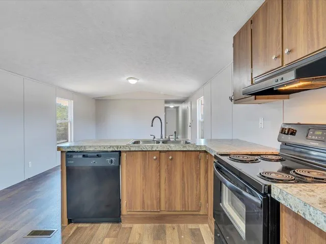 a kitchen with granite countertop a sink stove and cabinets
