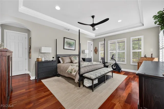 a spacious bedroom with a bed a couch and a chandelier