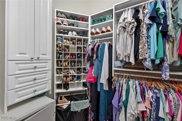 a view of walk in closet with clothes and shoes
