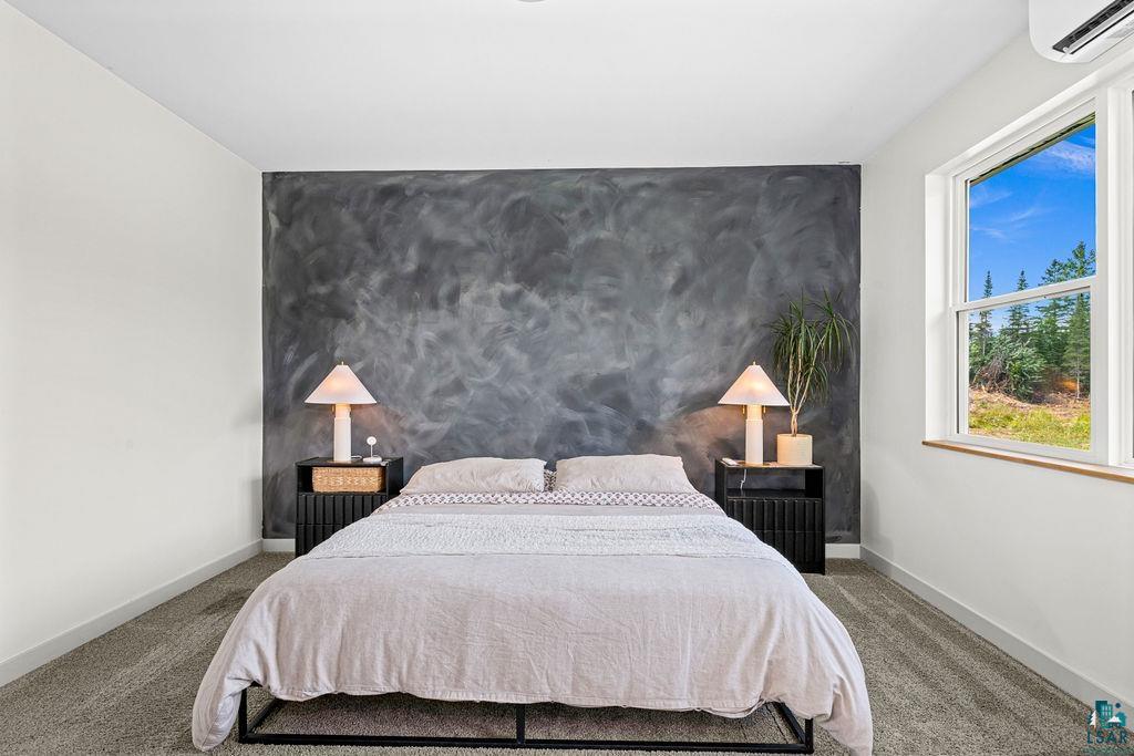 1873 East Shilhon Road Duluth, MN 55804 - Photo 16 of 26 Textured accent wall, carpeted flooring, white walls, double-hung window, and wall-mounted climate control unit