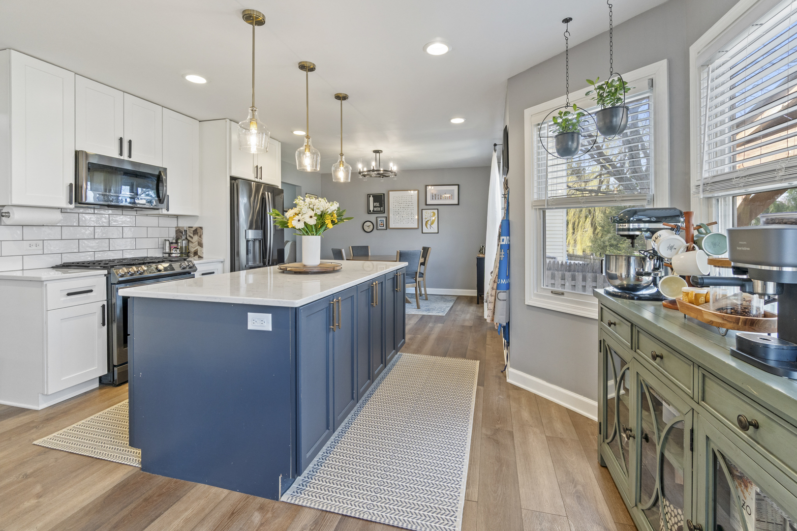 946 Pin Oak Circle Cary, IL 60013 - Photo 5 of 35 a large kitchen with stainless steel appliances kitchen island granite countertop a stove a sink dishwasher and a white cabinets with wooden floor
