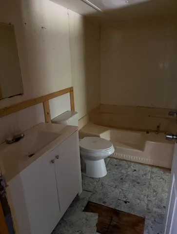 a white toilet sitting next to a bathroom sink