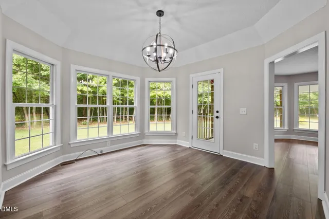 a view of an room with wooden floor fan and windows