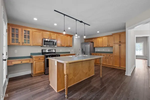 a kitchen with stainless steel appliances a stove a sink and a refrigerator