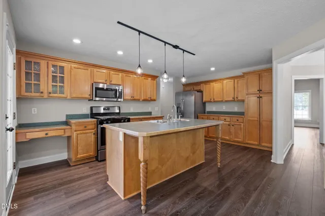 a kitchen with stainless steel appliances a stove a sink and a refrigerator
