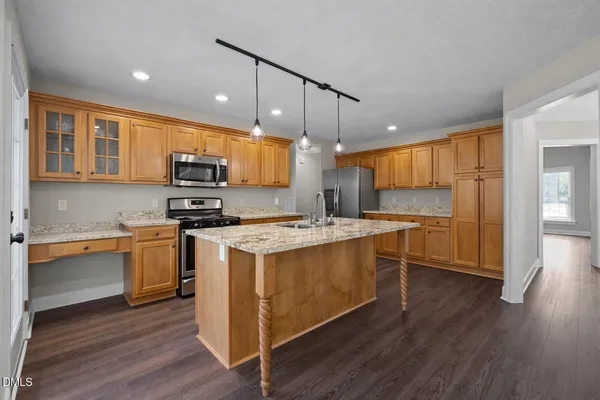 a kitchen with stainless steel appliances a stove a sink and a refrigerator