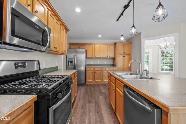 a kitchen with stainless steel appliances granite countertop a stove a sink and a refrigerator