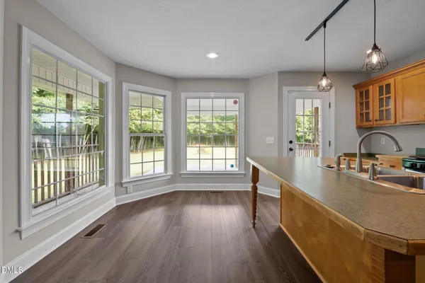 a view of a kitchen with wooden floor and windows
