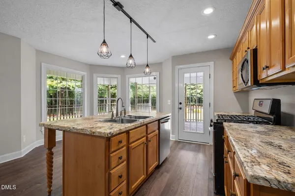 a kitchen with stainless steel appliances granite countertop counter space and wooden floors