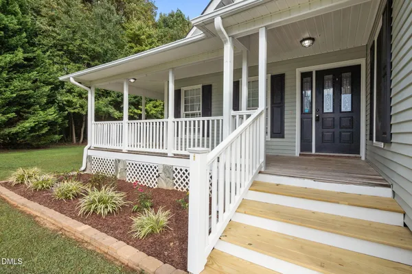 a view of a house with a small yard and wooden floor and fence