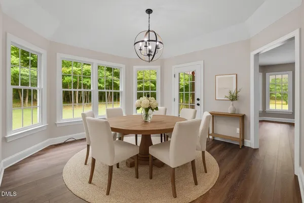 a dining room with furniture a chandelier and wooden floor