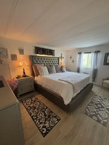 a bedroom with bed rug and window