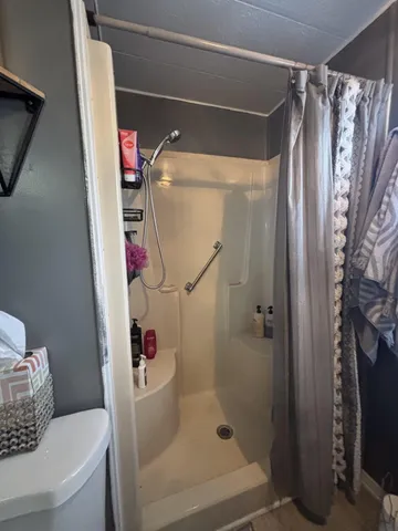 a bathroom with a shower toilet and sink
