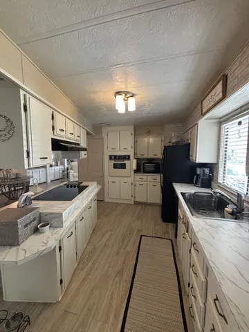 a large kitchen with stainless steel appliances granite countertop a stove a sink dishwasher and a refrigerator