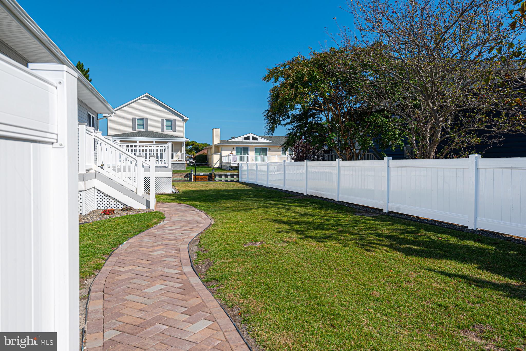138 Old Wharf Road Ocean City, MD 21842 - Photo 3 of 33 a view of a white house in front of a big yard with potted plants