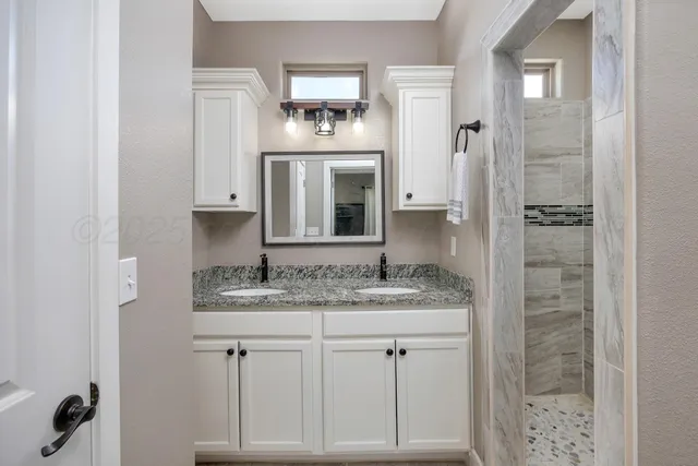 a bathroom with a granite countertop sink and a mirror