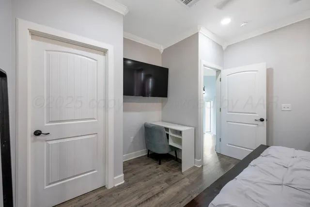 a view of a bedroom with a bed and wooden floor