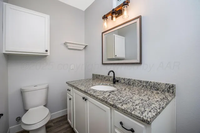 a bathroom with a toilet sink and mirror