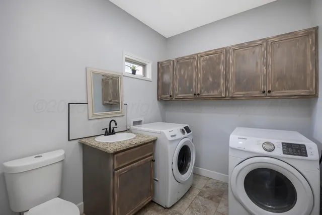 a utility room with sink dryer and washer
