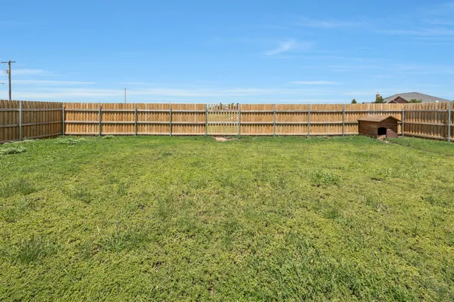 a view of a yard with wooden fence
