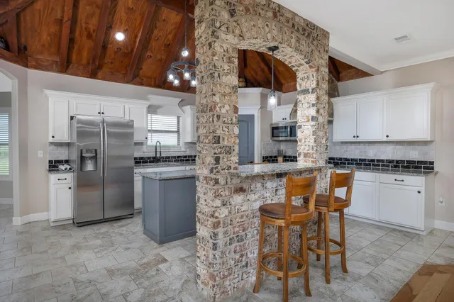 a kitchen with refrigerator and chairs