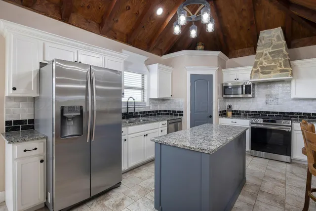 a kitchen with stainless steel appliances granite countertop a stove sink and refrigerator