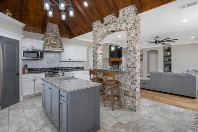 a kitchen that has a lot of cabinets in it and stainless steel appliances