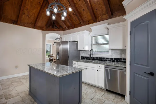 a kitchen with stainless steel appliances granite countertop a sink and a refrigerator