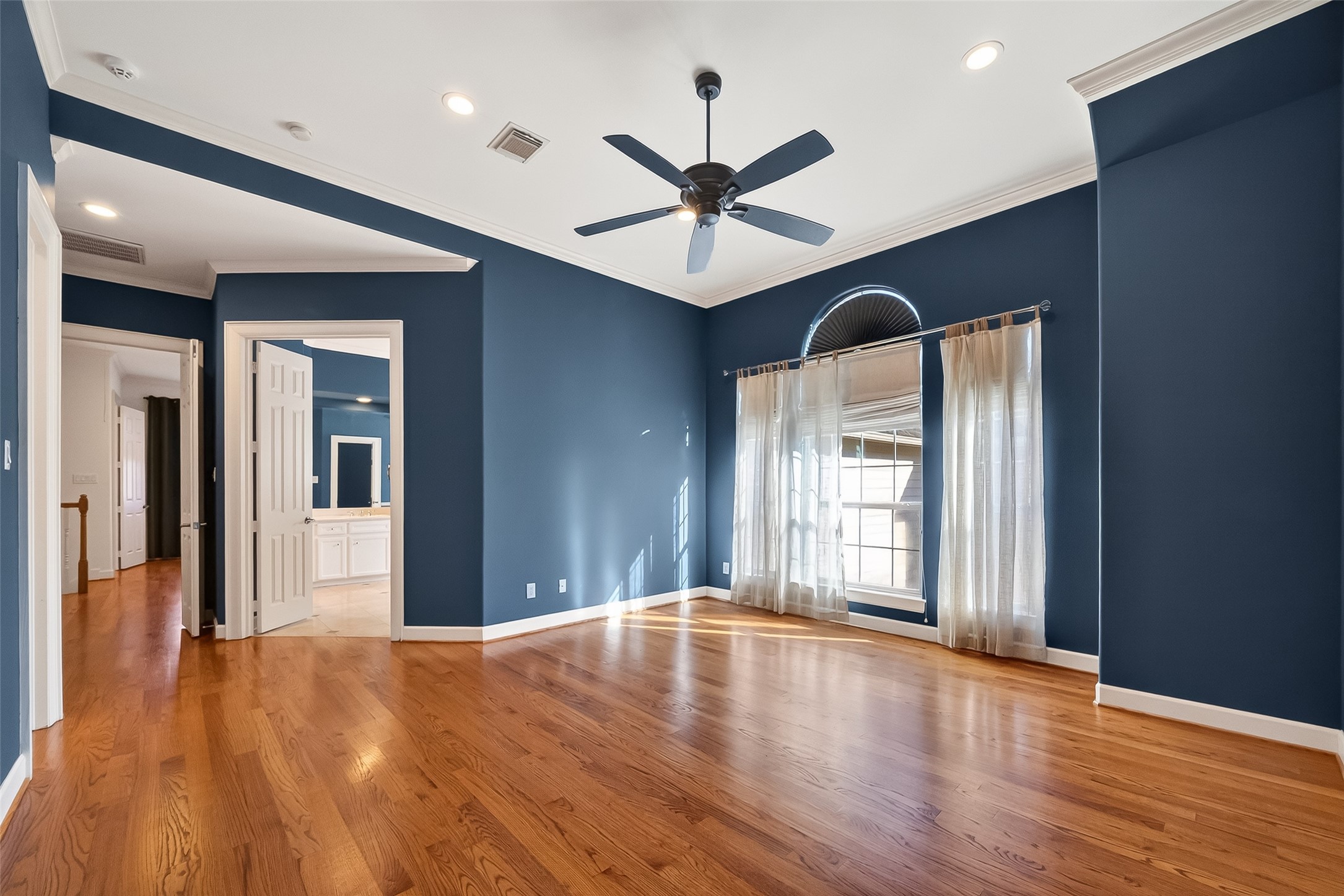 1004 Stanford Street, Unit A Houston, TX 77019 - Photo 27 of 38 This executive style primary bedroom offers all the space needed with custom paint, wall of windows and natural wood flooring.