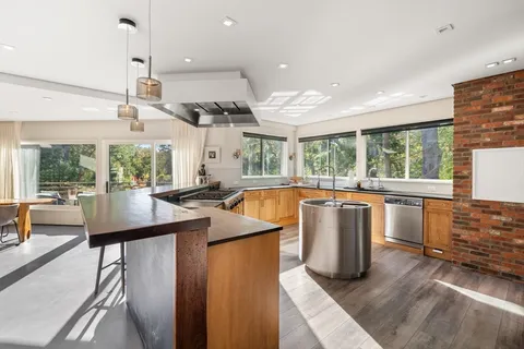 a kitchen with lots of counter space windows and a view of living room
