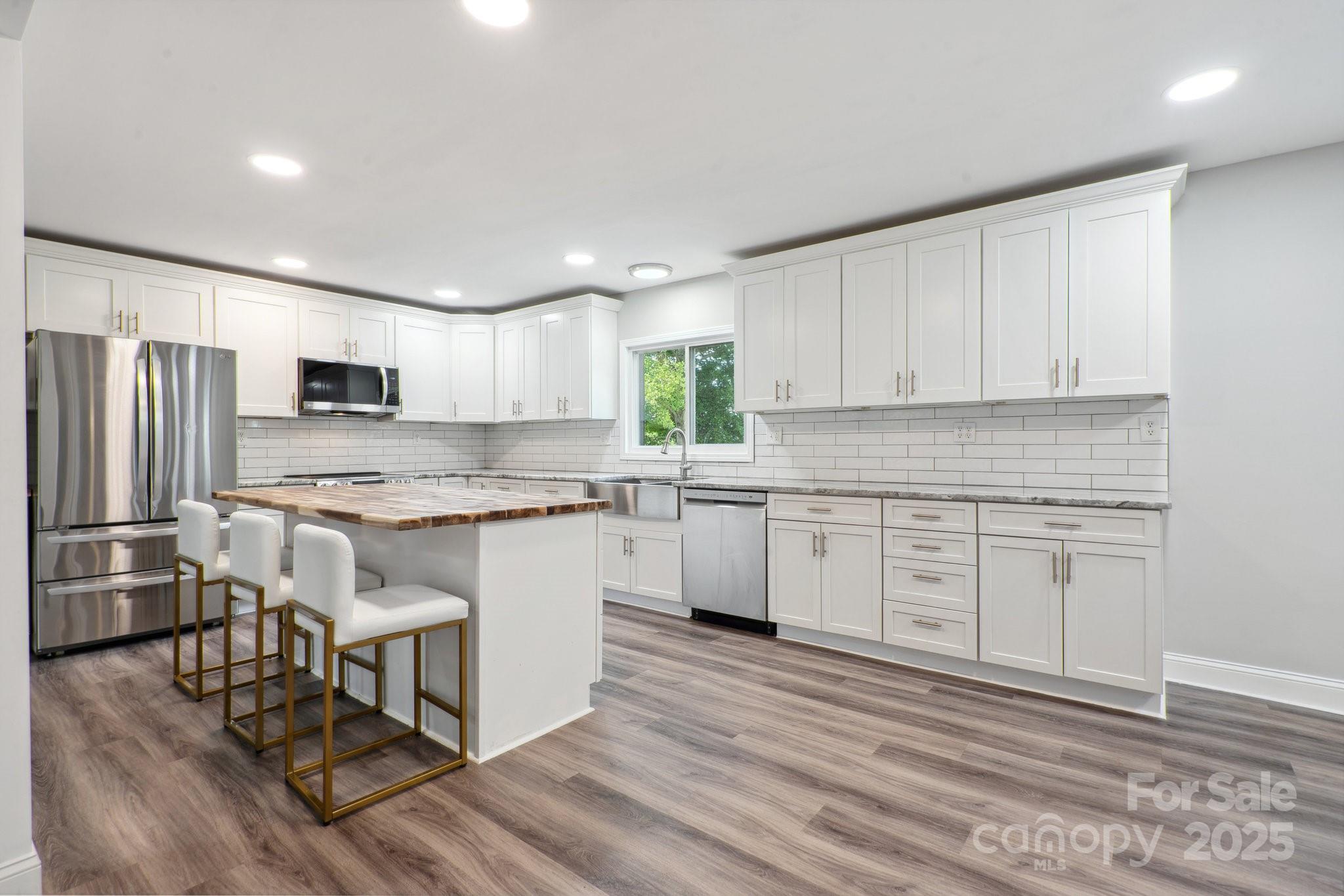 554 Isle Of Pines Road Mooresville, NC 28117 - Photo 11 of 44 a kitchen with granite countertop white cabinets and stainless steel appliances