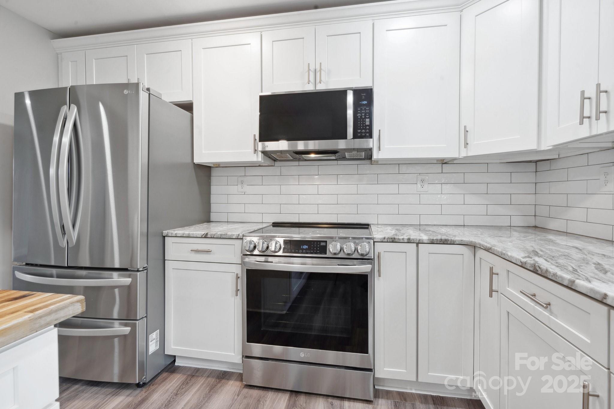 554 Isle Of Pines Road Mooresville, NC 28117 - Photo 13 of 44 a kitchen with stainless steel appliances white cabinets a stove and a refrigerator