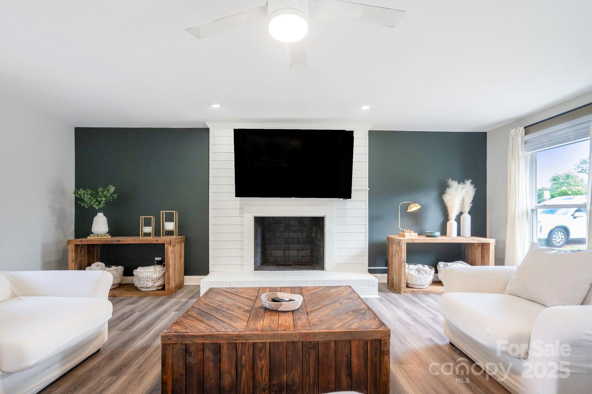 554 Isle Of Pines Road Mooresville, NC 28117 - Photo 19 of 44 a living room with furniture a fireplace and a flat screen tv