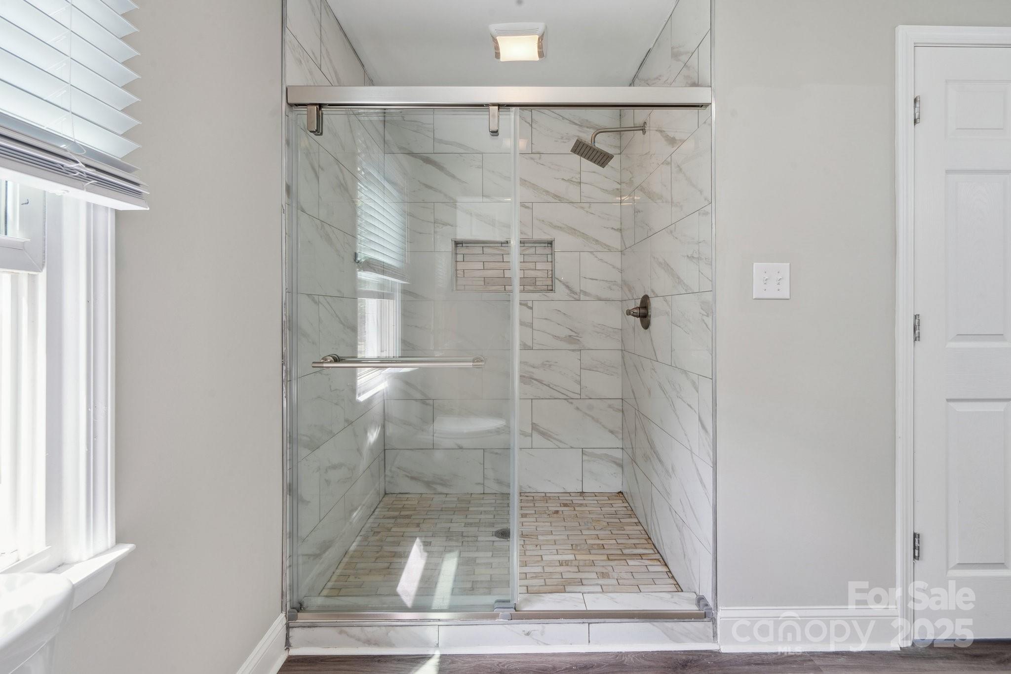 554 Isle Of Pines Road Mooresville, NC 28117 - Photo 23 of 44 a bathroom with a glass shower door