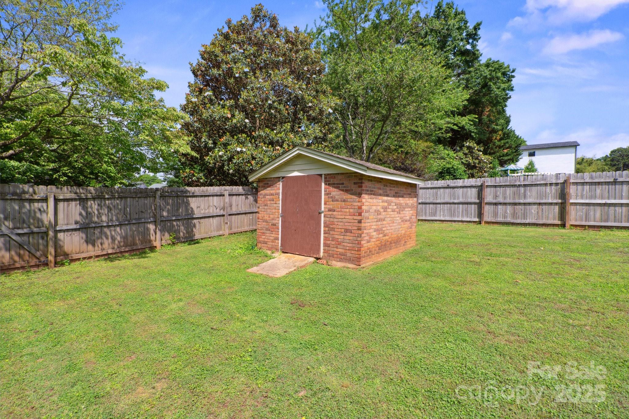 554 Isle Of Pines Road Mooresville, NC 28117 - Photo 37 of 44 a view of a backyard with a small cabin and wooden fence