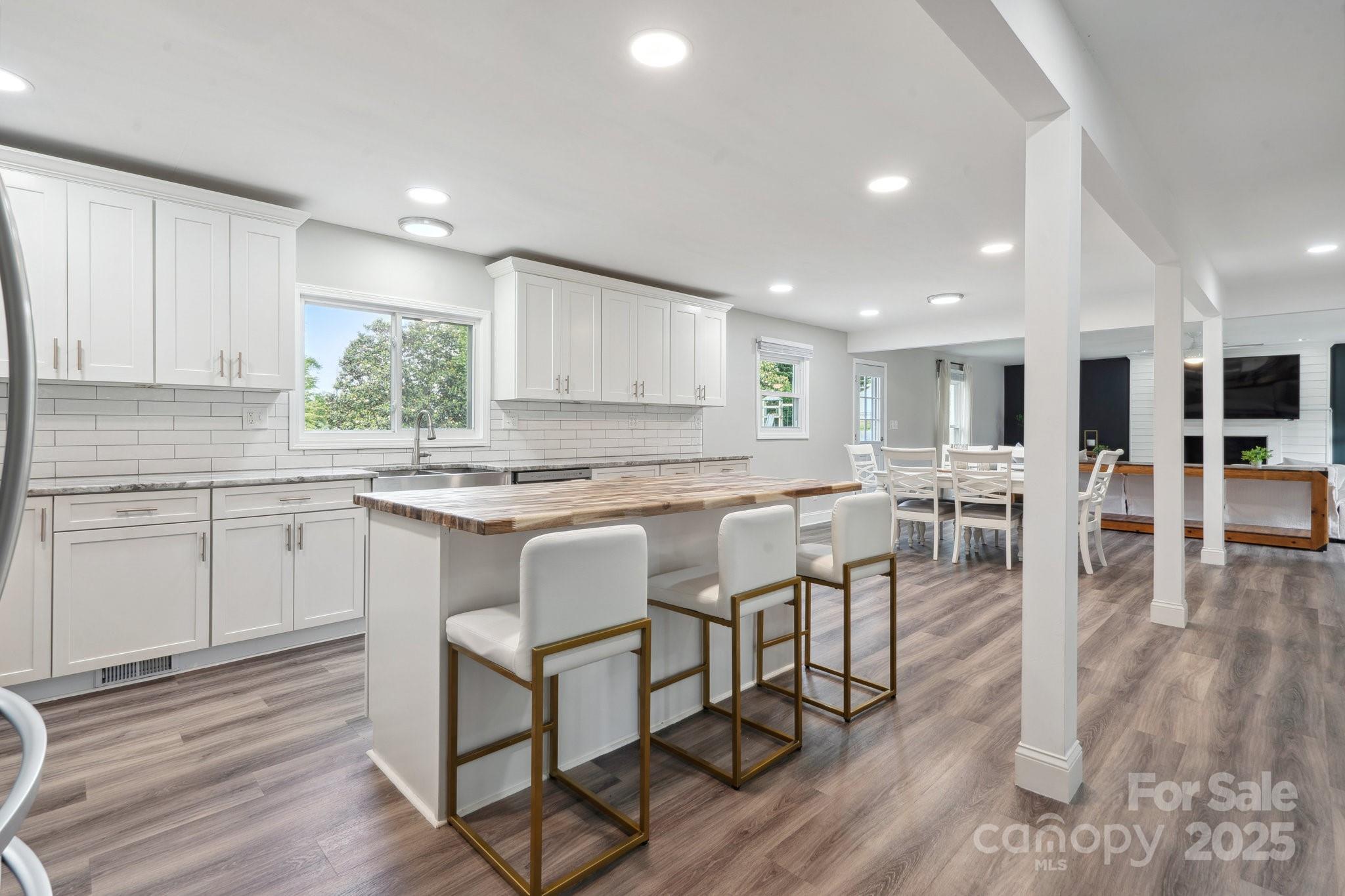 554 Isle Of Pines Road Mooresville, NC 28117 - Photo 10 of 44 a kitchen with stainless steel appliances granite countertop a stove a sink a oven a dining table and chairs with wooden floor