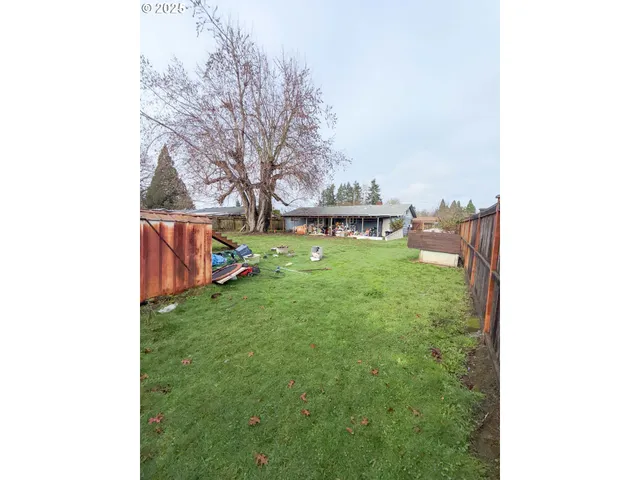 a backyard of a house with table and chairs