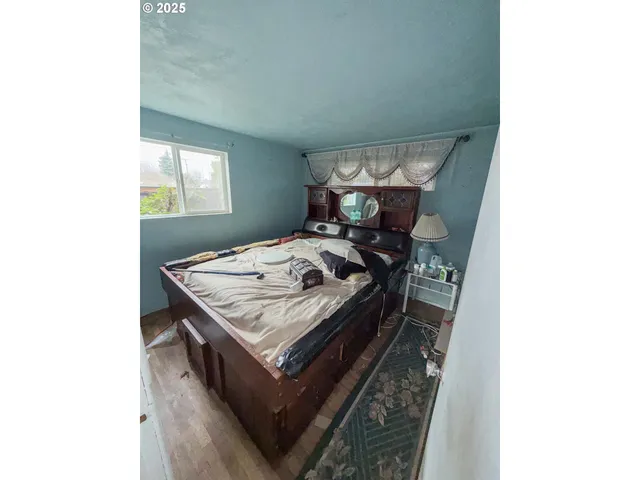 a bed sitting in a bedroom next to a window