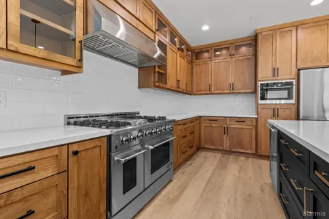 a kitchen with stainless steel appliances granite countertop a stove a sink dishwasher and a refrigerator