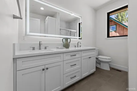 a bathroom with a toilet a sink and mirror