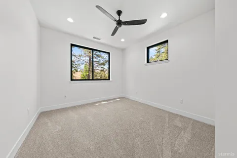 an empty room with a window and a ceiling fan