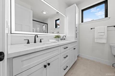 a bathroom with double vanity sink and mirror