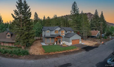 a front view of a house with a yard and trees