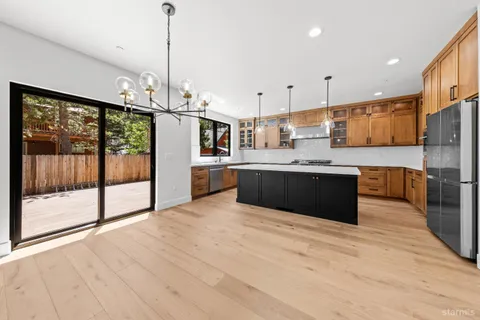 a large kitchen with kitchen island a large counter top stainless steel appliances and cabinets