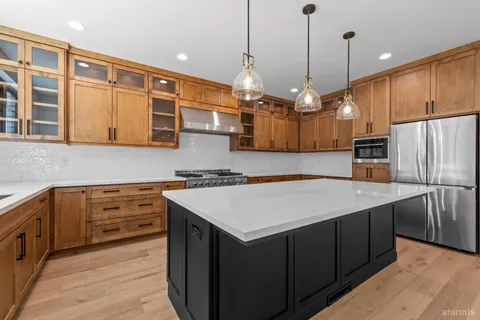 a kitchen with kitchen island a sink a center island a stove and a refrigerator