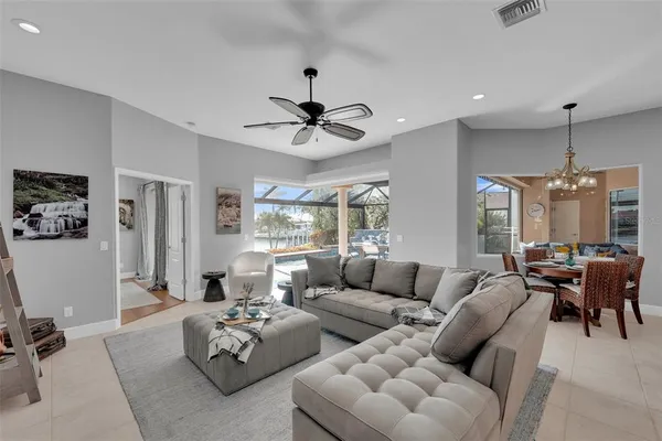 a living room with furniture kitchen view and a chandelier