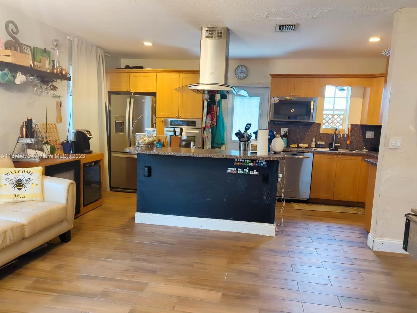 14735 Southwest 302nd Street Homestead, FL 33033 - Photo 4 of 23 a kitchen with stainless steel appliances granite countertop a refrigerator a sink dishwasher and a stove with wooden floor
