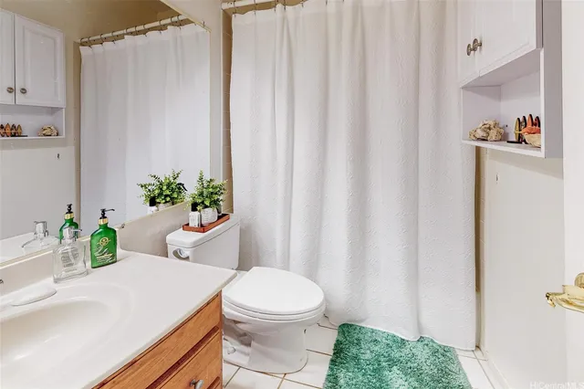 a bathroom with a sink a toilet and shower curtain